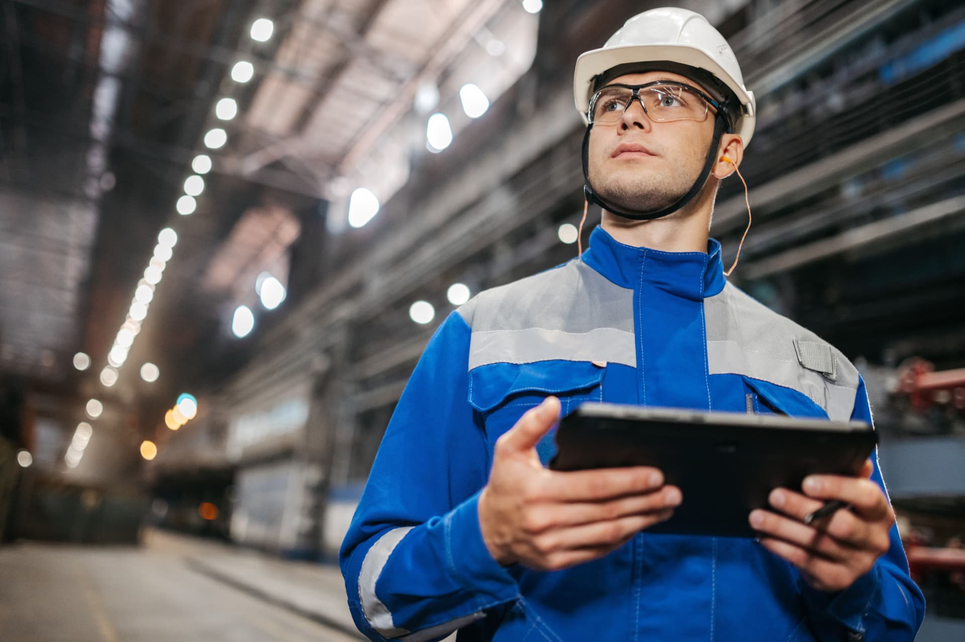 Industriefachkraft mit Tablet in einer Produktionshalle