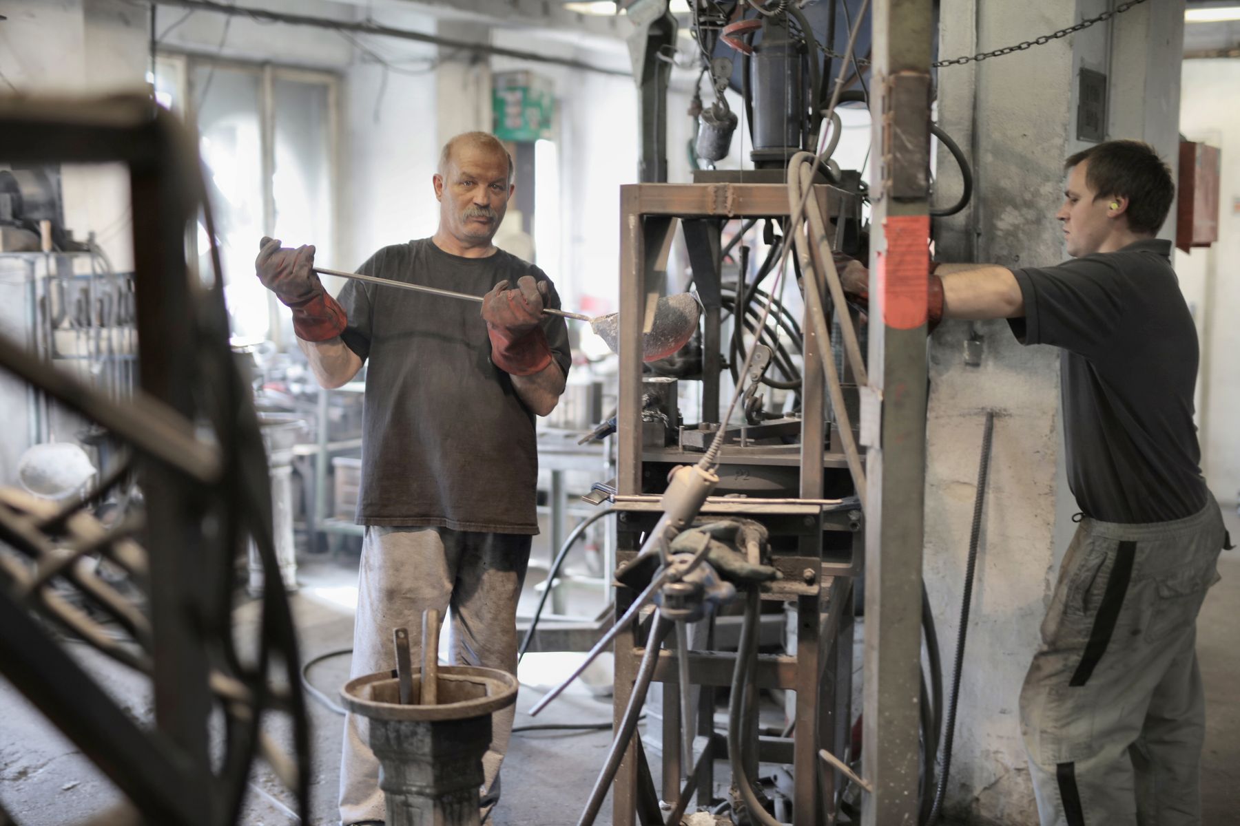 Zwei technische Fachkräfte im Austausch an einer Industriemaschine